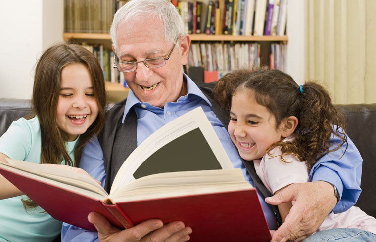 grandfather reading to young granddaughters