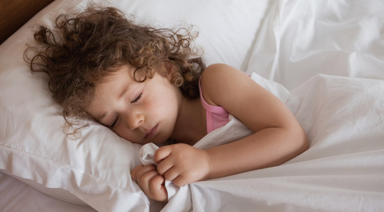 young girl sleeping soundly in bed