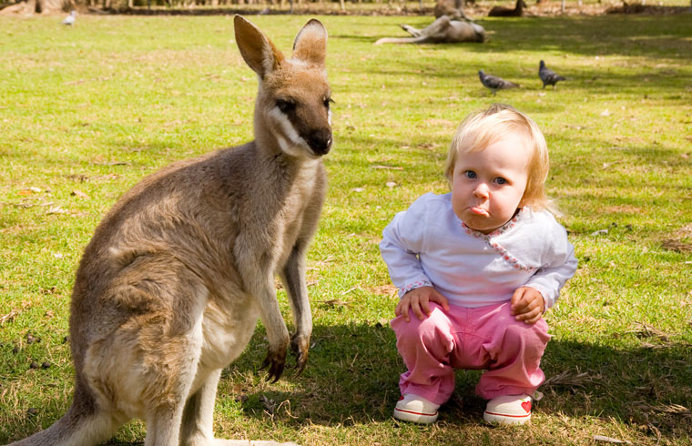 young girl with pouty face next to kangeroo