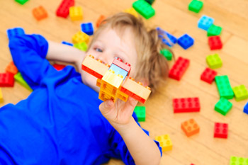 boy playing with plastic building blocks