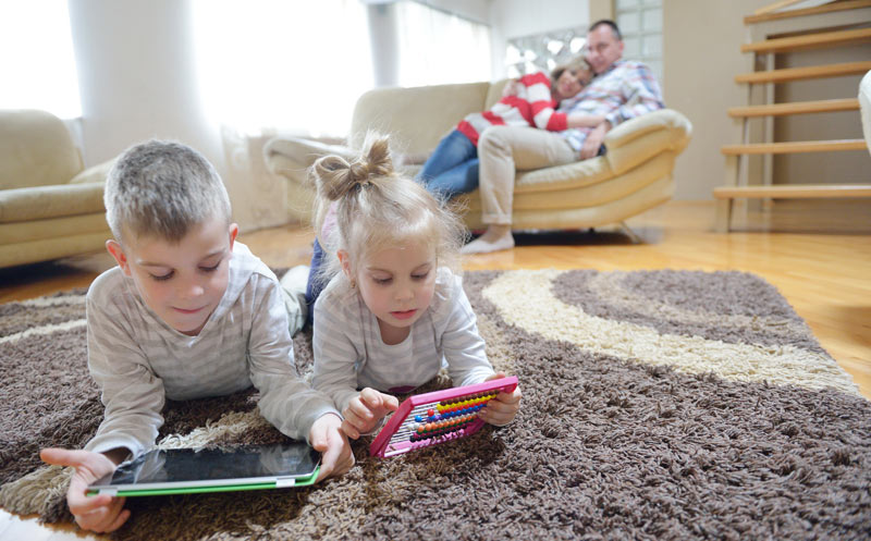 brother and sister playing on the floor in the living room