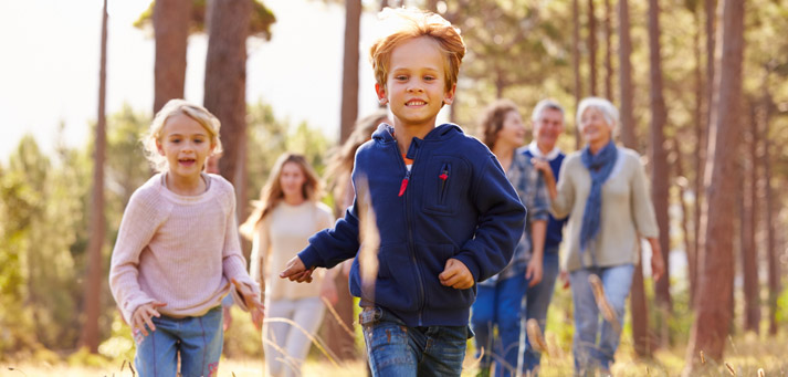 children racing through the woods on a path
