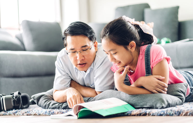 dad and daughter discussing something that they found in a book