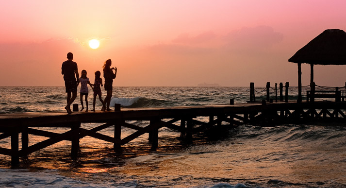 family at ocean on vacation during sunset