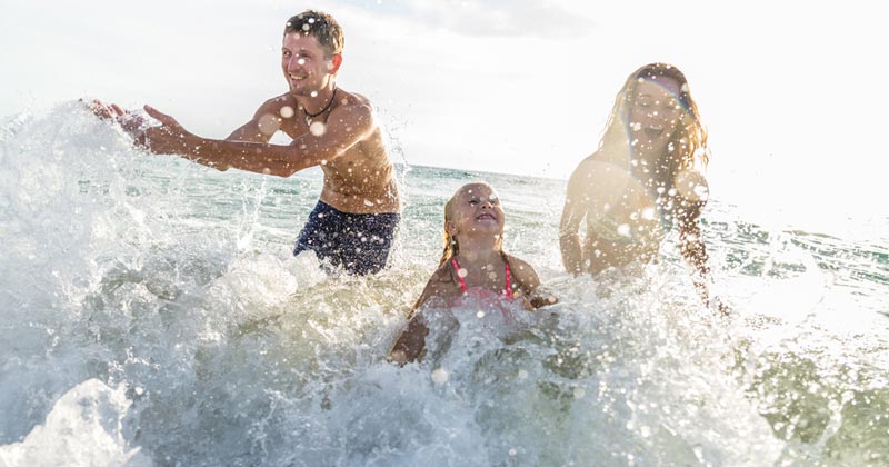 family having fun splashing water in the lake