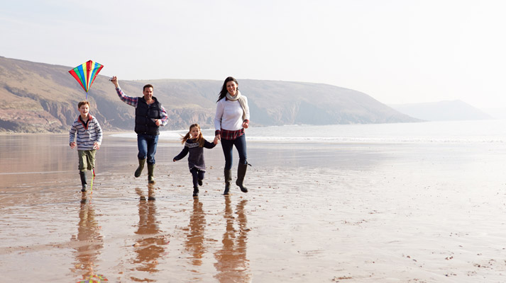 family walking along the shore
