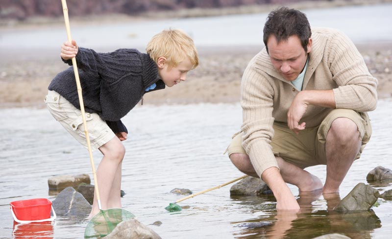 father and son fishing with net and pole