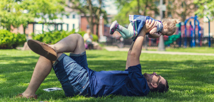 father on the grass with his young daughter