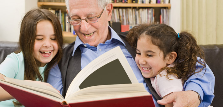Grandpa reading a story book to his grandchildren