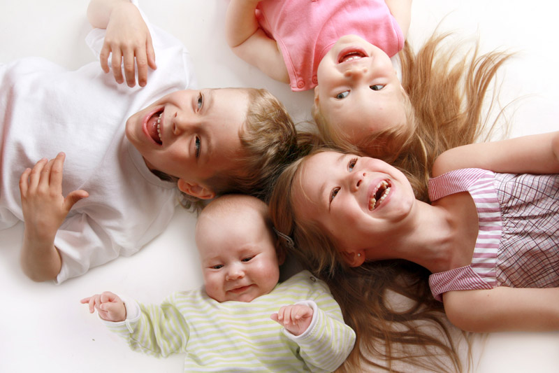 group of young siblings on the floor laughing