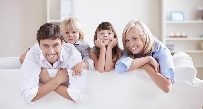 happy family leaning over from the front of the couch