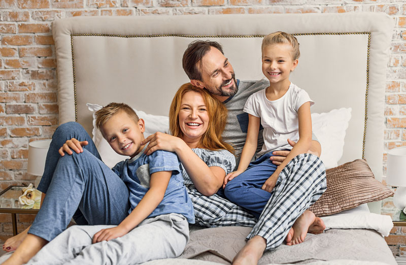 happy family posing on a bed for a picture