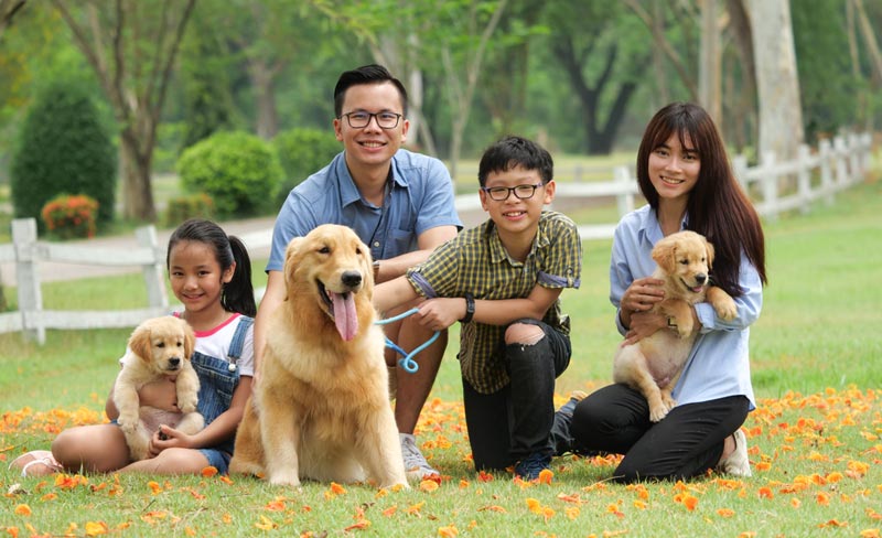 happy family posing with mother dog and puppy