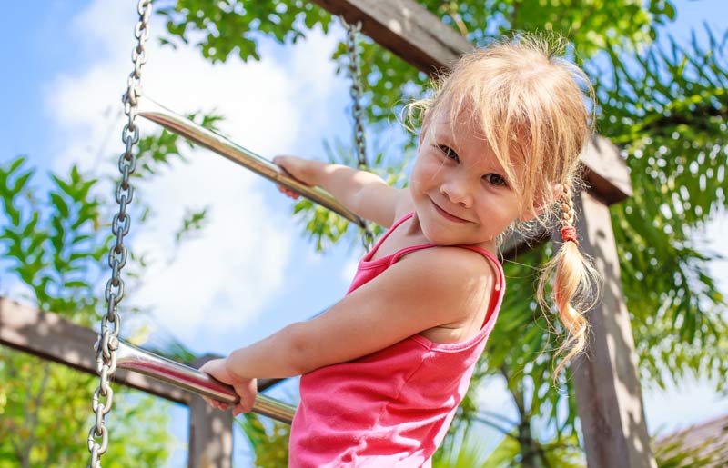 happy little girl having fun climbing up the playground