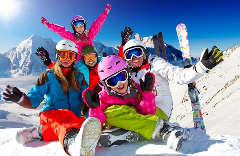 happy snowboarding skiing family