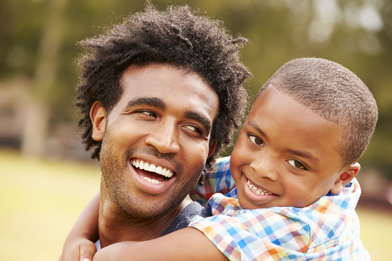 happy young boy hugging his father