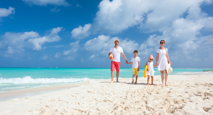 happy young family walking along a sandy beach