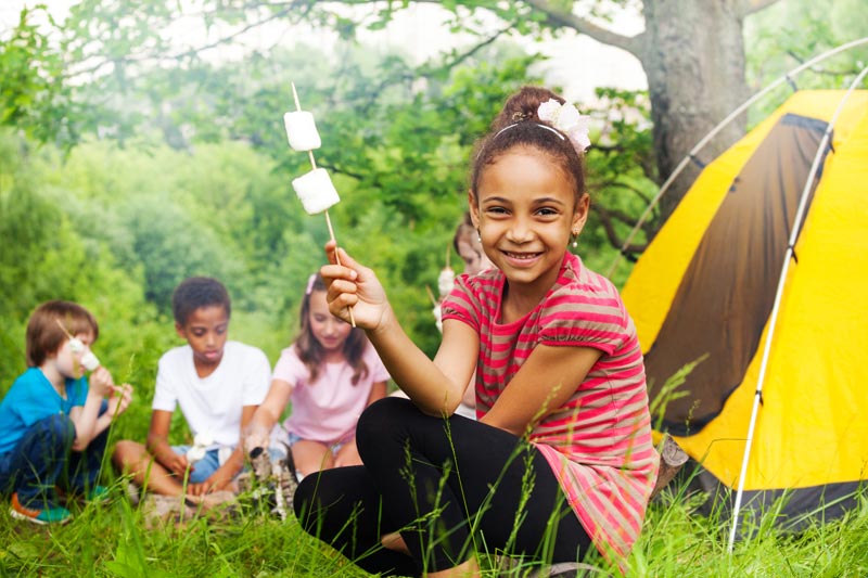 kids camping with tents and roasting marshmallows