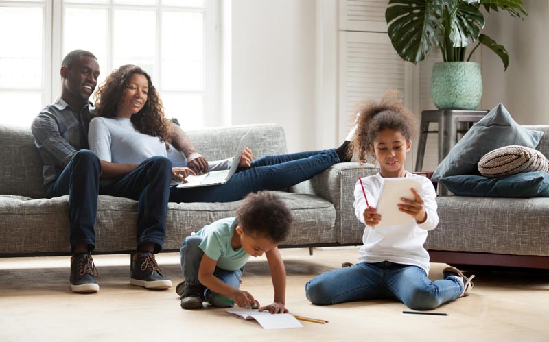 kids drawing on paper on living room floor