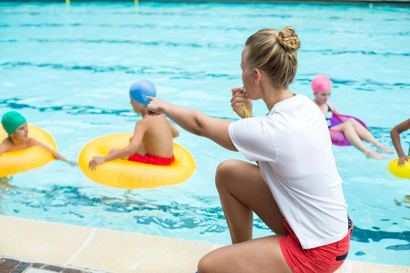 lifeguard blowing whistle and getting swimmers attention