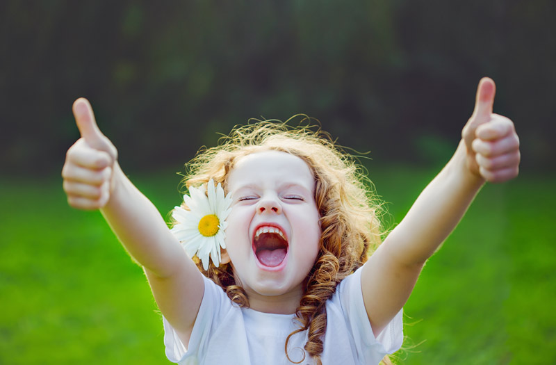 little flower hair girl giving a thumbs up