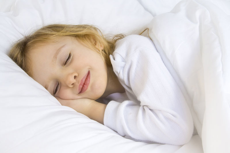 little happy girl soundly sleeping in bed