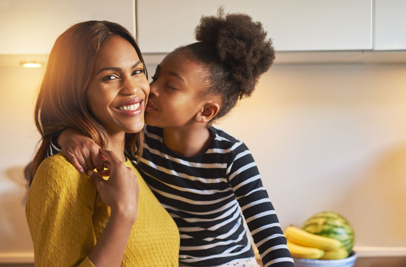 loving young girl kissing her mother