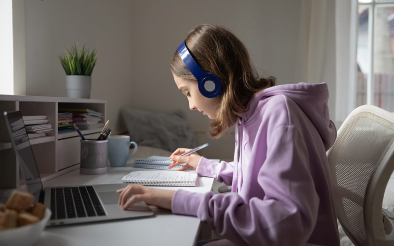 middle school girl working on her homework while sitting at a desk