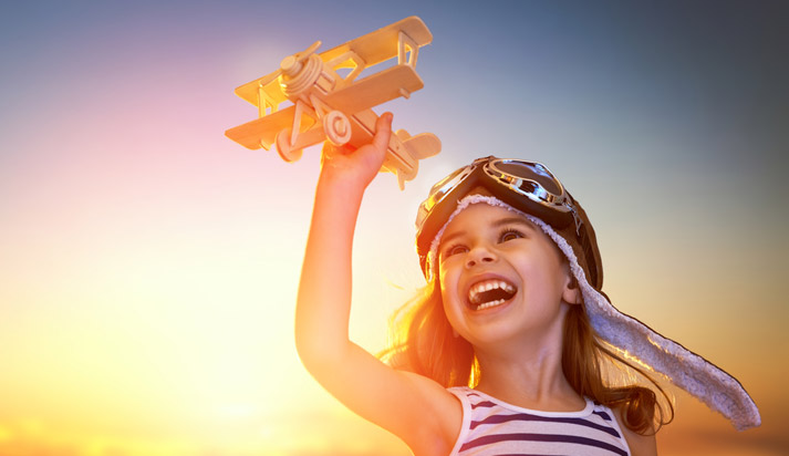 young child playing with a model airplane