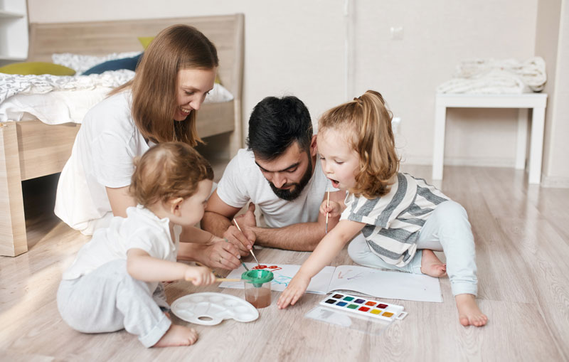 mom and dad painting with two toddlers