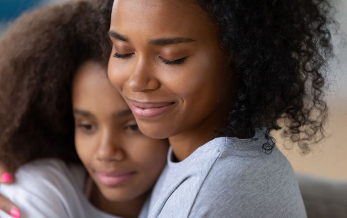 mom comforting and snuggling her teenage daughter