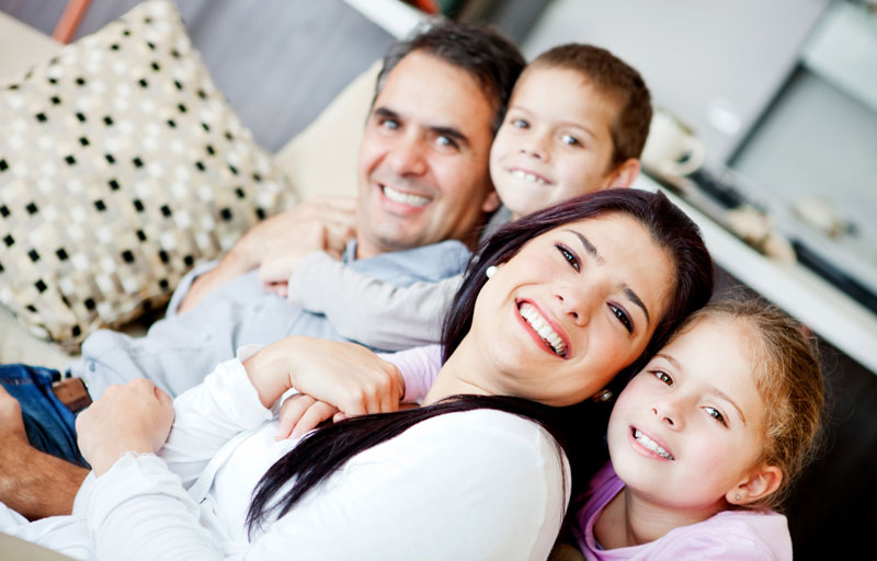 mom and dad smiling with two happy kids