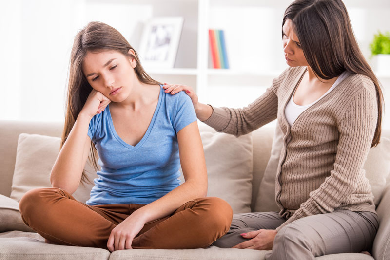 mother comforting her upset teen daughter