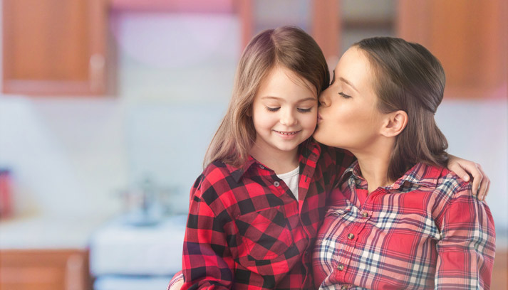 mother kissing young daughter