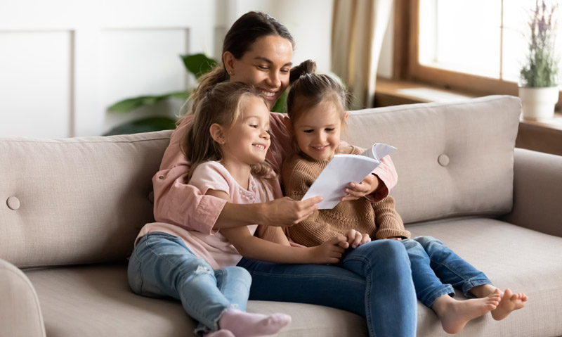 mother reading to two young daughters