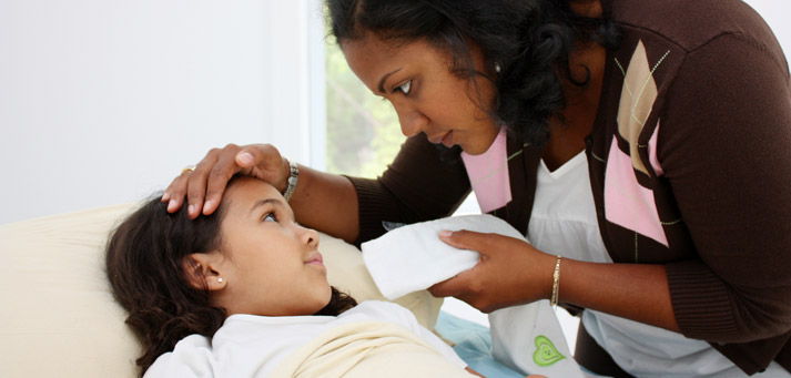 mother tending to daughter who is ill and not feeling well