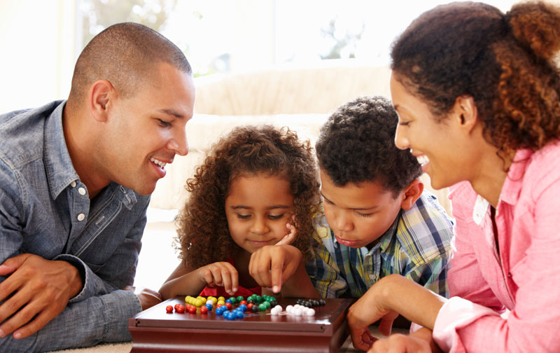 parents with children playing board games