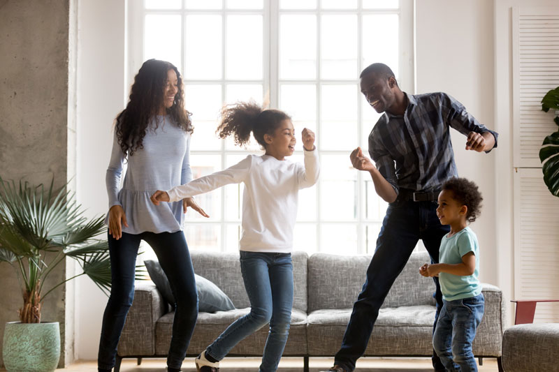 parents with kids dancing in the living room