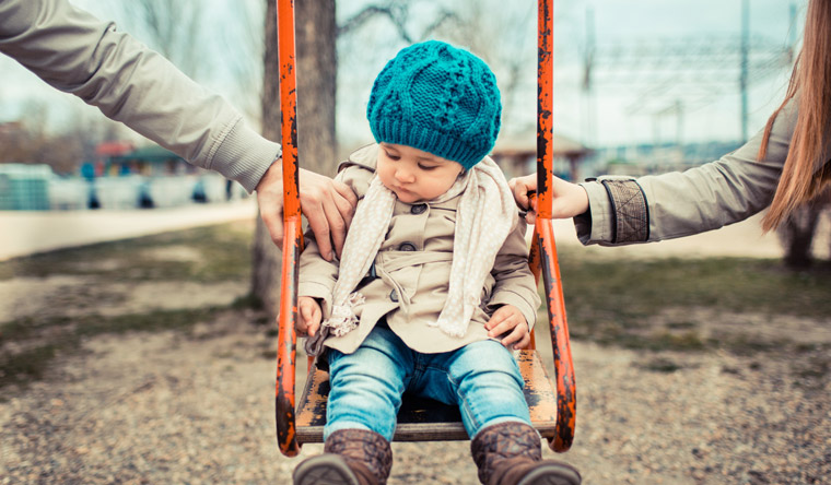 parents with young daughter on swing