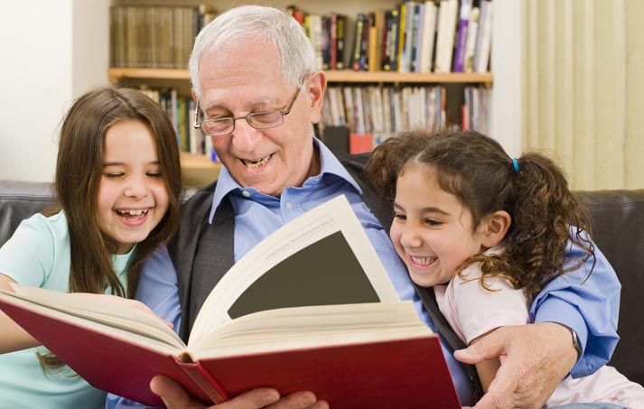 grandfather reading a story to his grandchildren