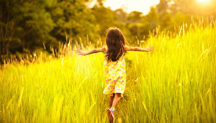 young girl running through the tall grass