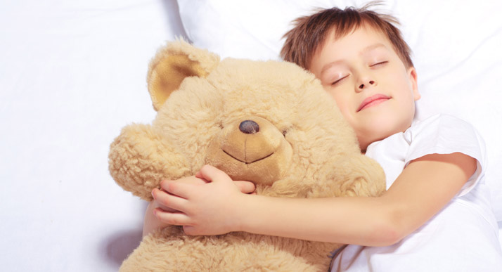 sleeping boy with large teddy bear