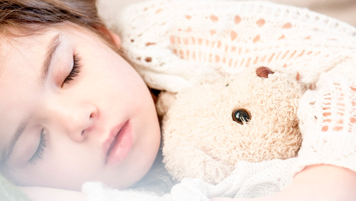 sleeping little child with teddy bear