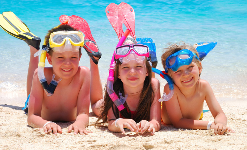 three siblings dressed up in gear for swimming underwater