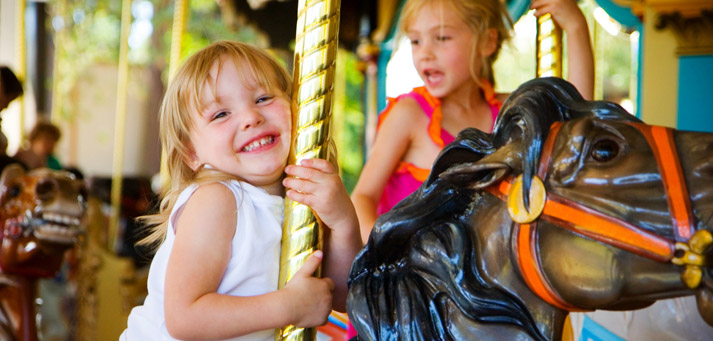 toddler girl riding a carousel