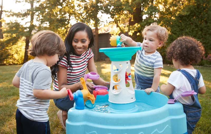 toddlers playing outside with water toys