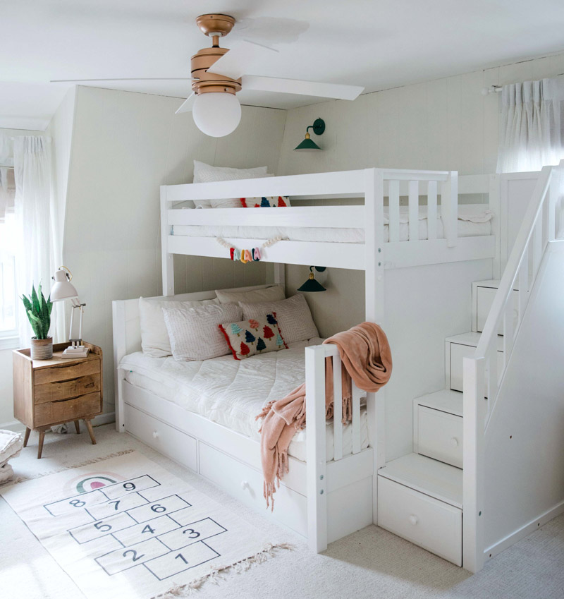 twin over full bunk bed with white finish in a simply decorated room with a fan