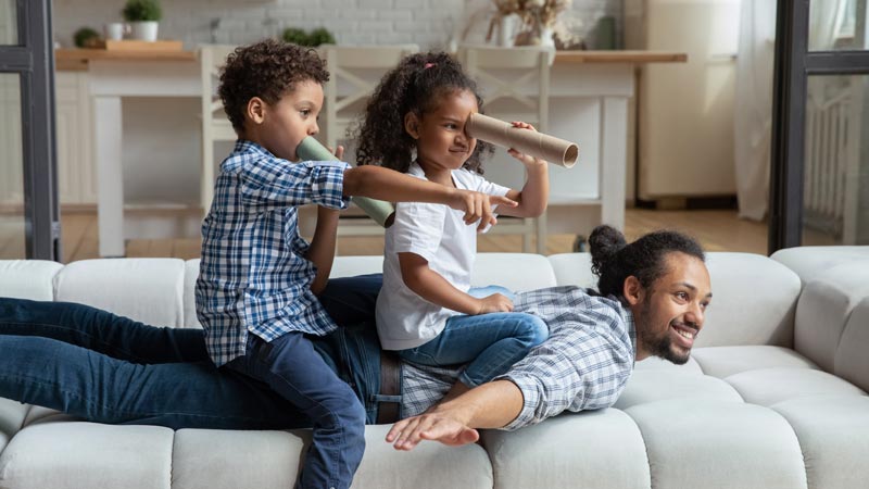 two kids riding on dad and having fun