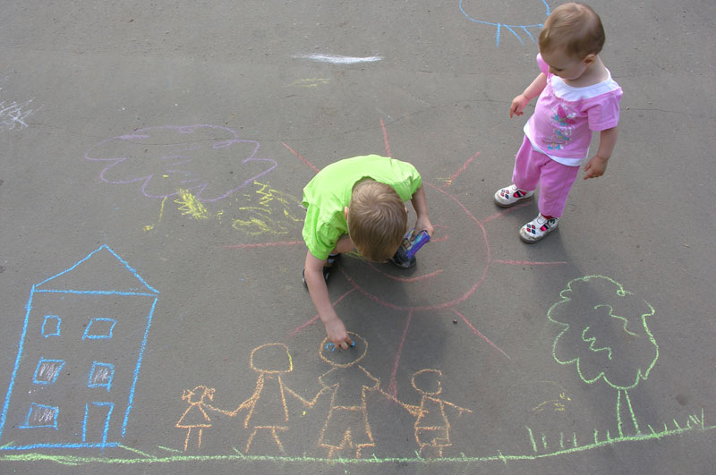 two little children being sidewalk chalk artists