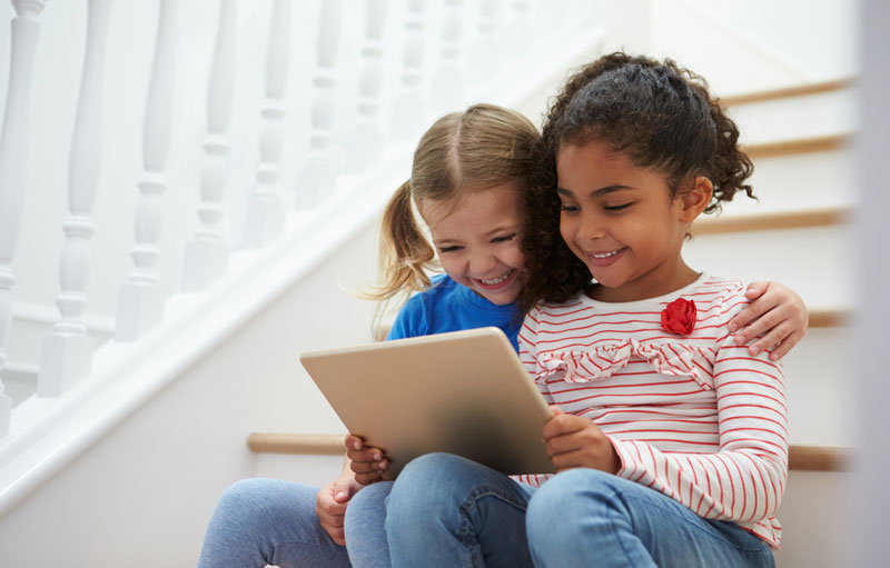 two little girls playing game on tablet